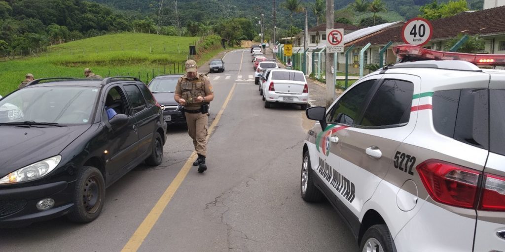 Policiais abordam veículos